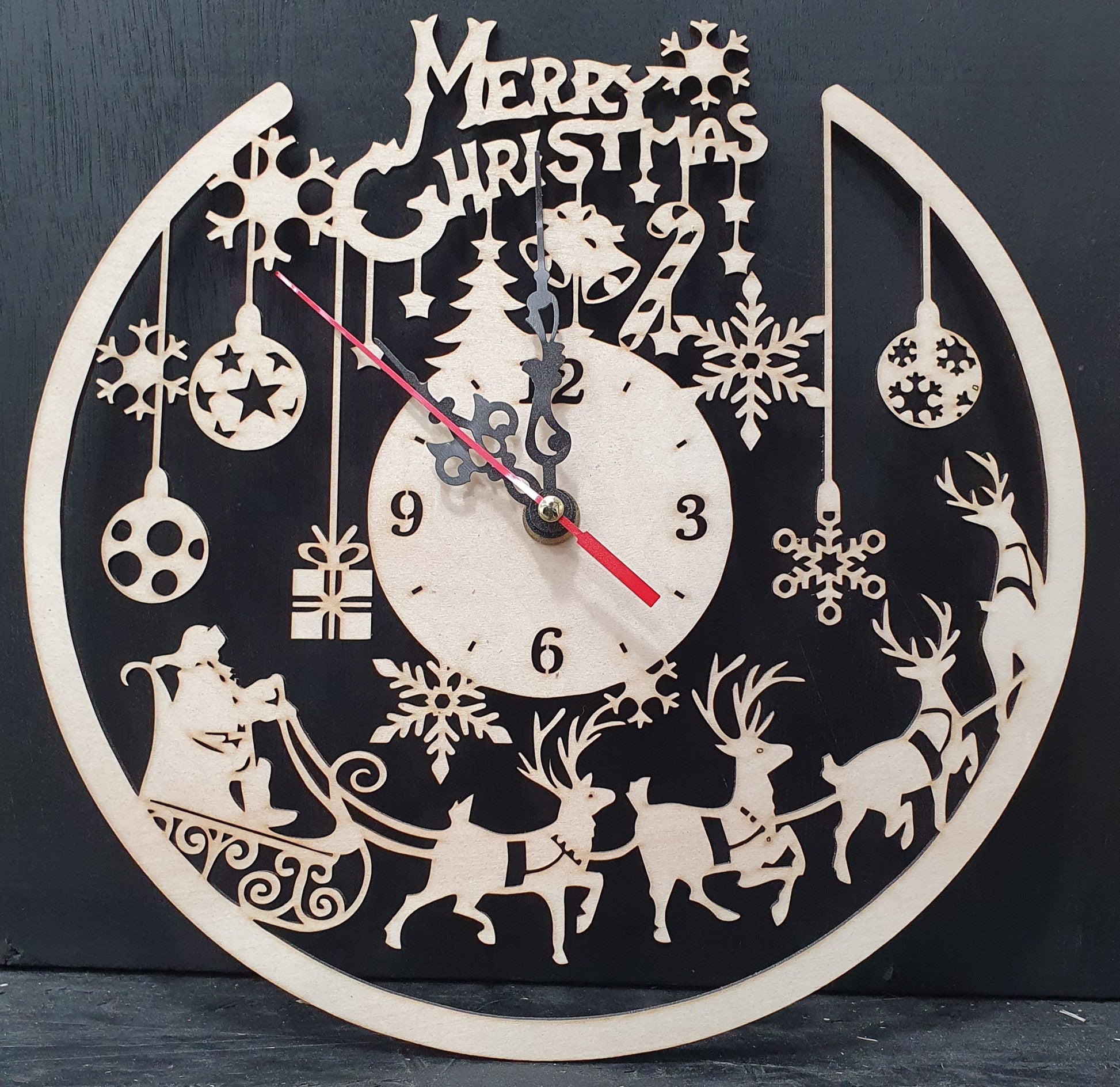 Decorative Christmas clock with reindeer, sleigh, and ornaments on a black background