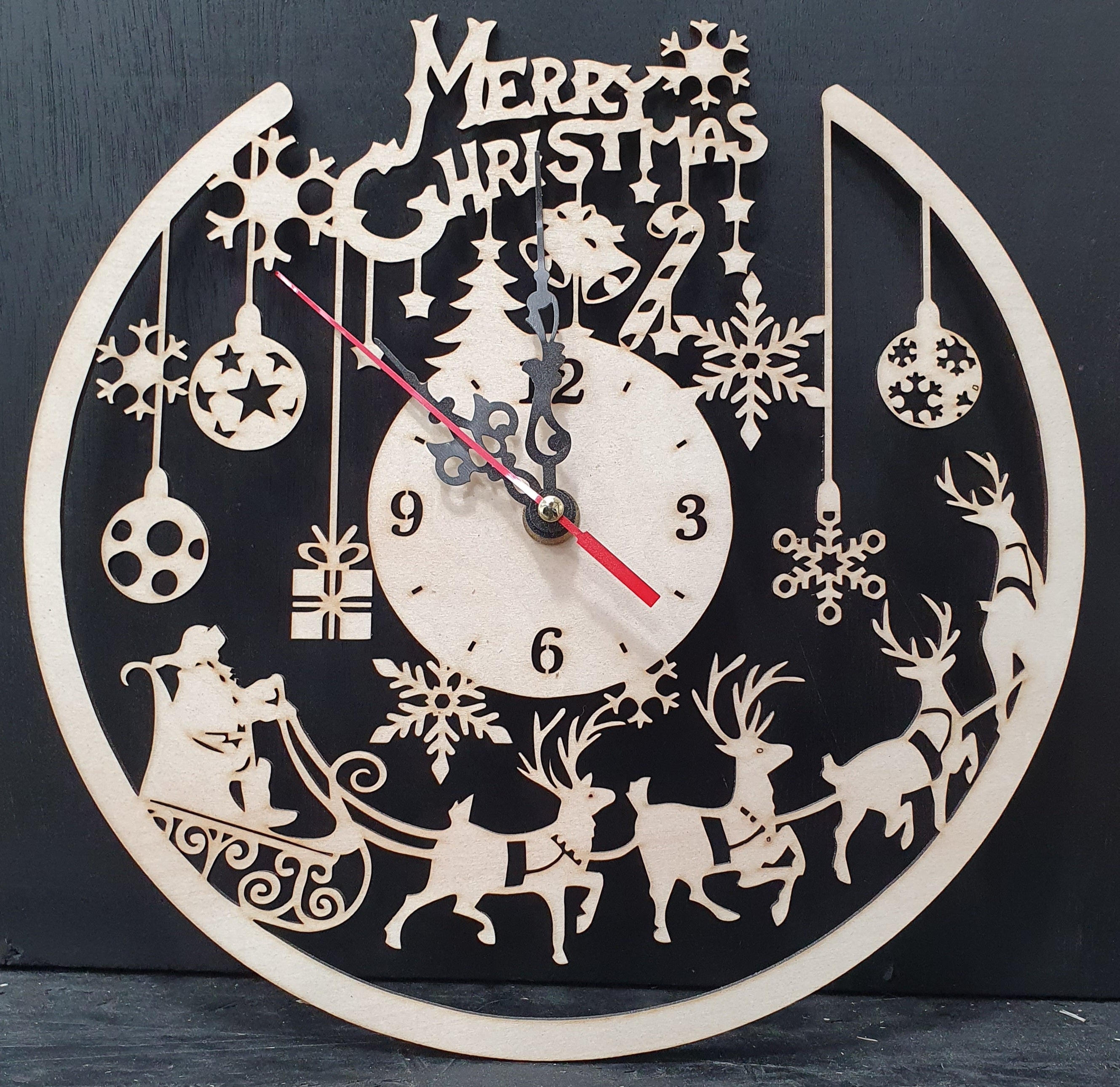 Decorative Christmas clock with reindeer, sleigh, and ornaments on a black background