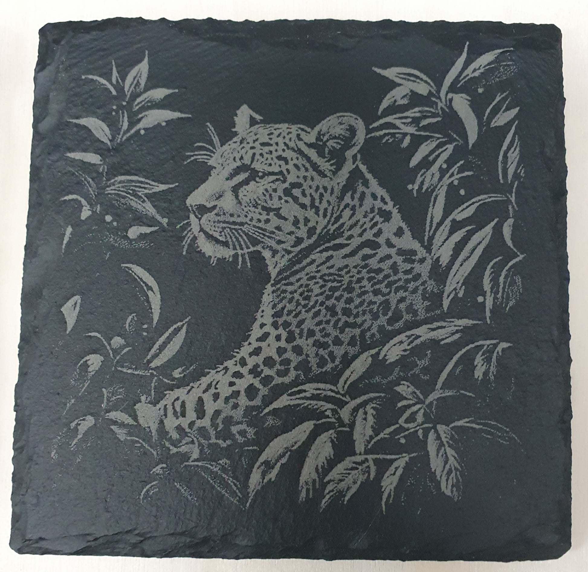 Slate coaster with engraved leopard design.