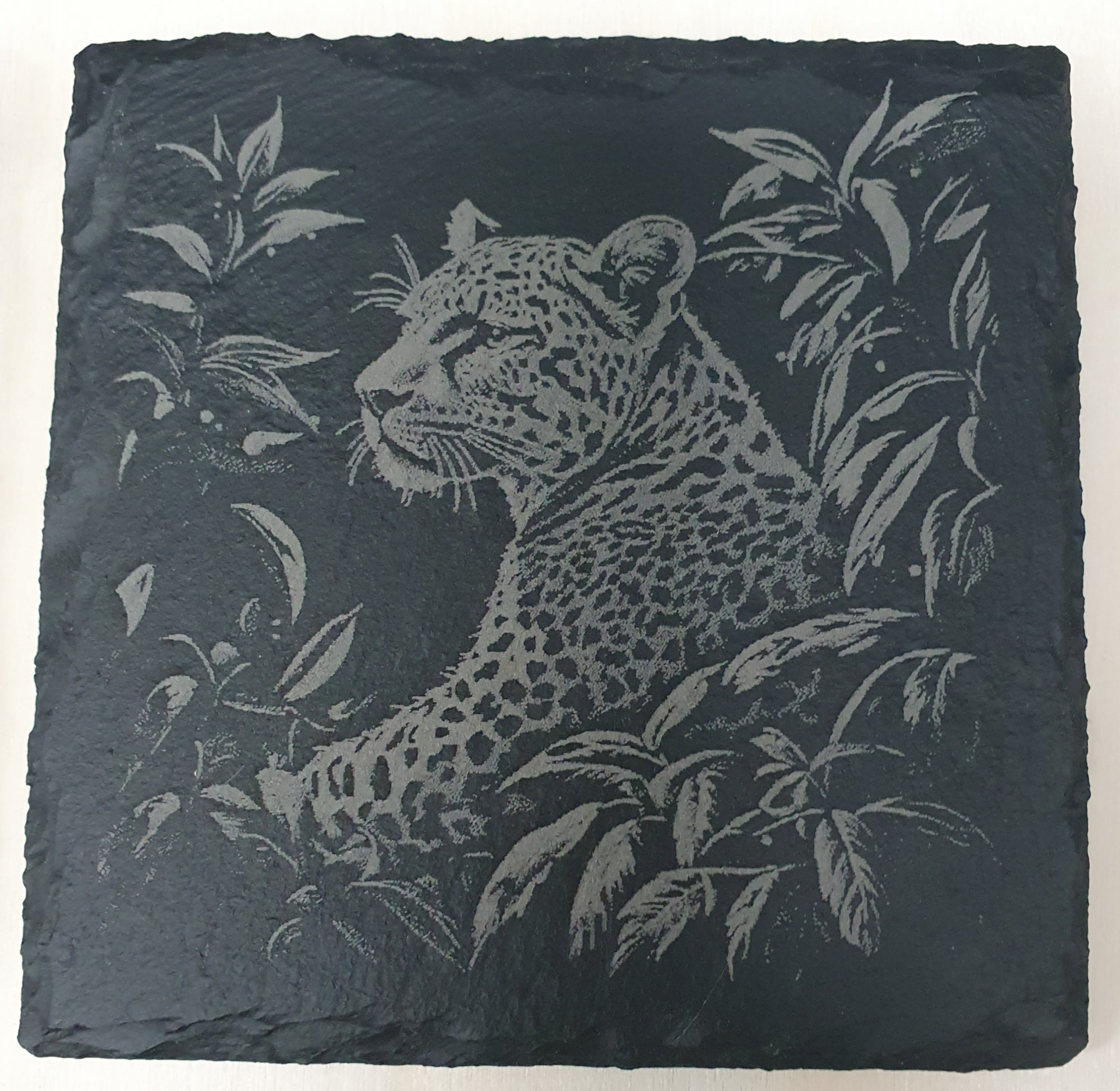 Slate coaster with engraved leopard design.