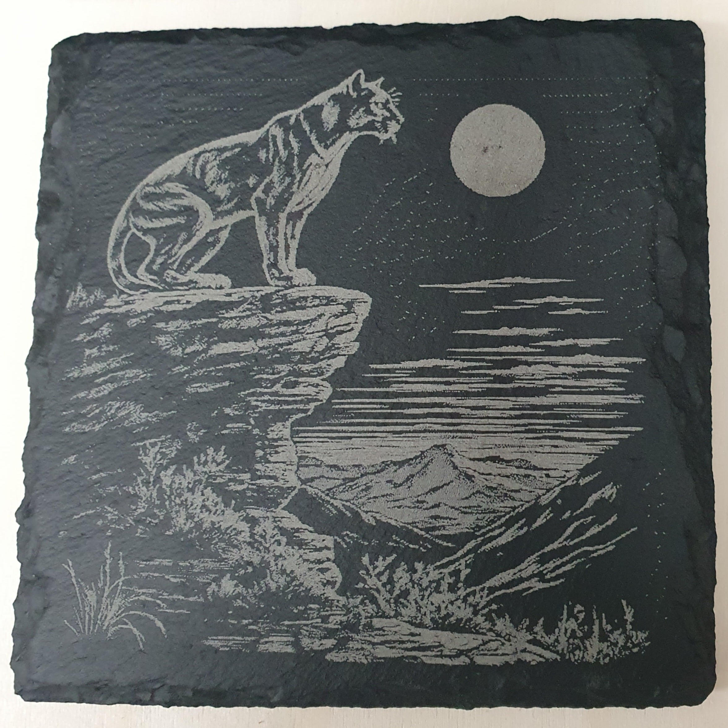 Slate with engraved image of a Panther on a rock at night.