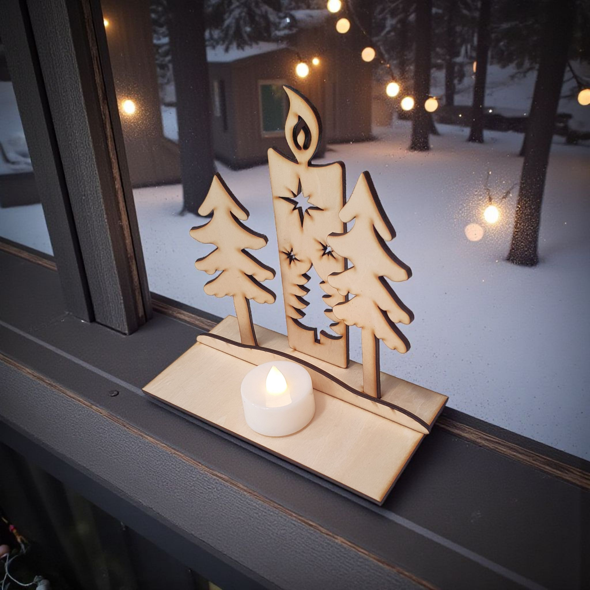 Decorative wooden candle holder with trees on a windowsill with a snowy outdoor background.