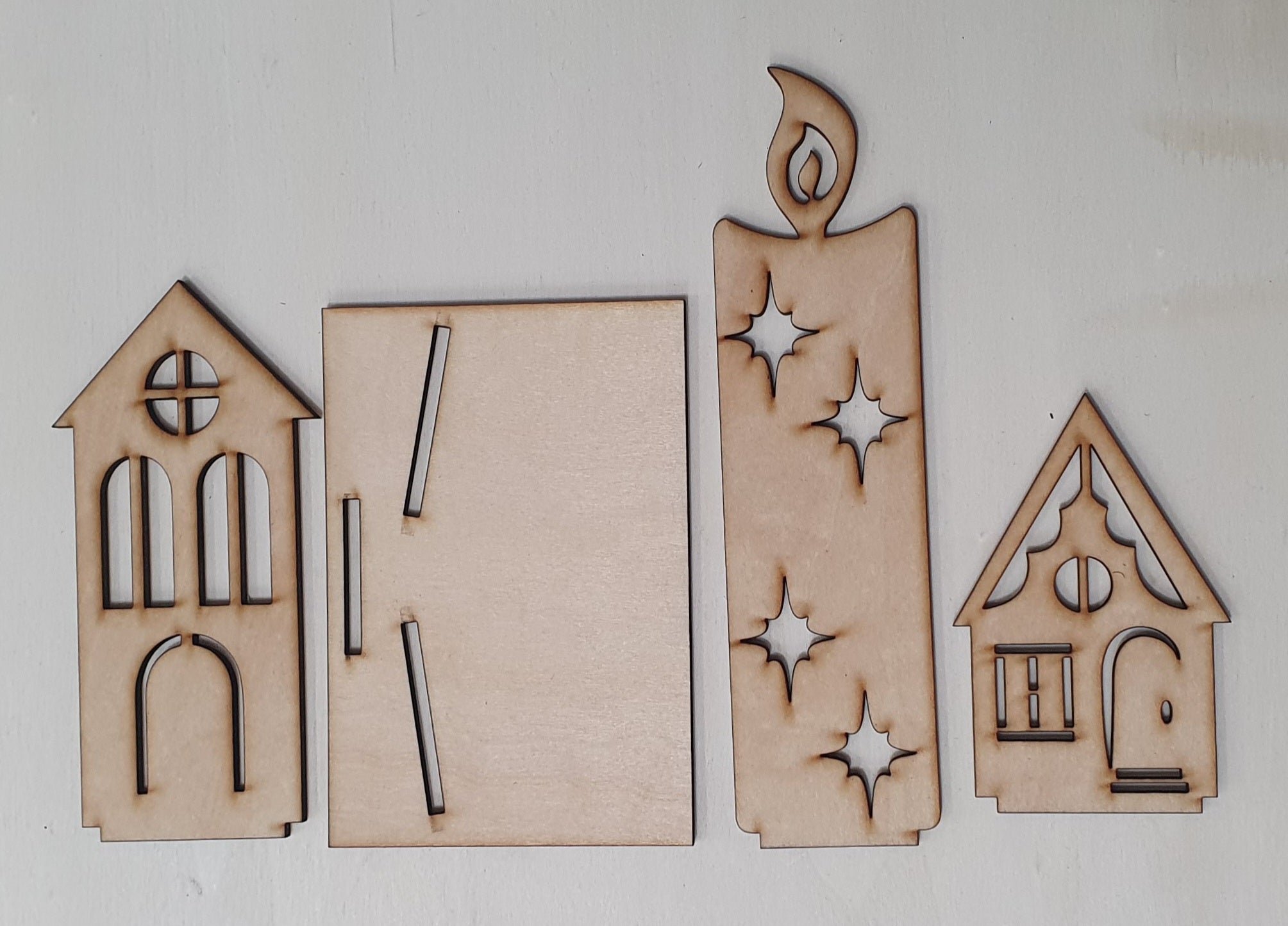 Set of wooden laser-cut house shapes on a white background