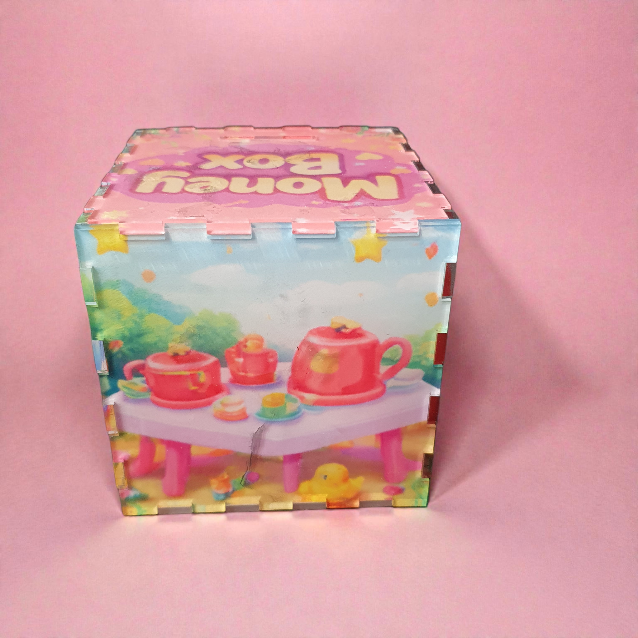Rear view of pastel toy-themed money box with tea set and playful nursery design.