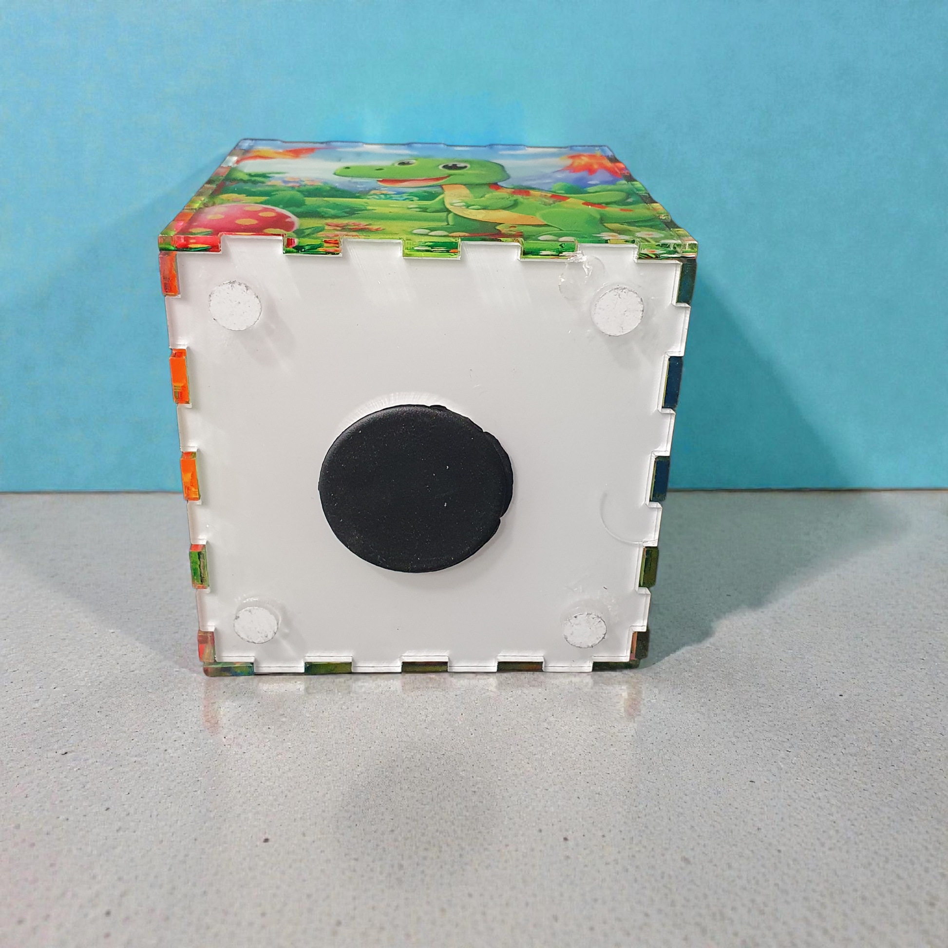 Bottom view of dinosaur money box showing removable base with rubber stopper for easy coin access.