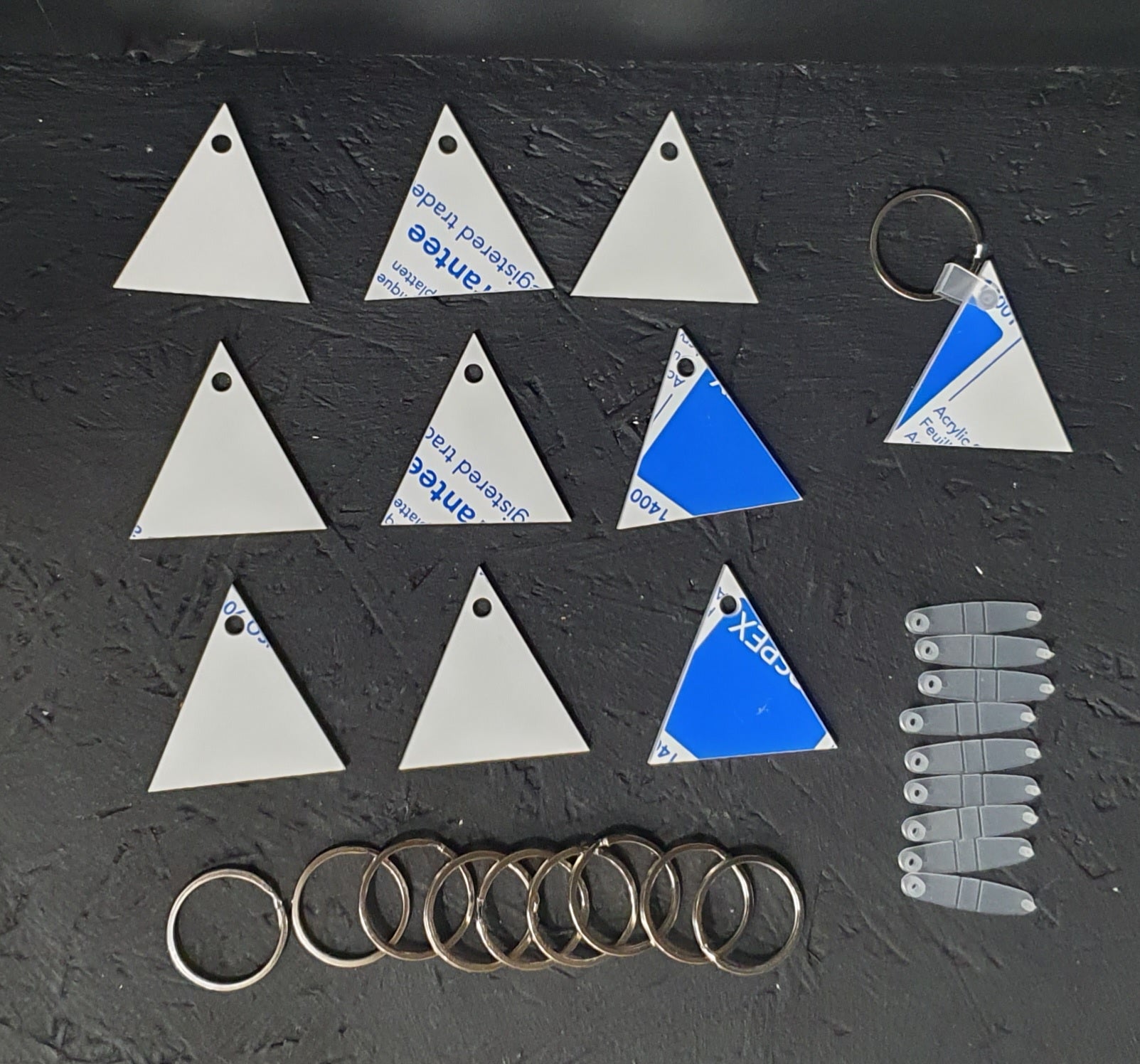 Triangle white acrylic keychain blank made from 3mm cast acrylic with protective film and 30mm keyring attachment ready for personalisation.