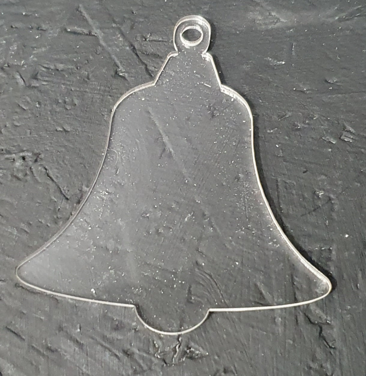 Close up of white acrylic bell blank showing smooth laser cut edges and 5mm hanging hole suitable for sublimation, vinyl and UV printing.