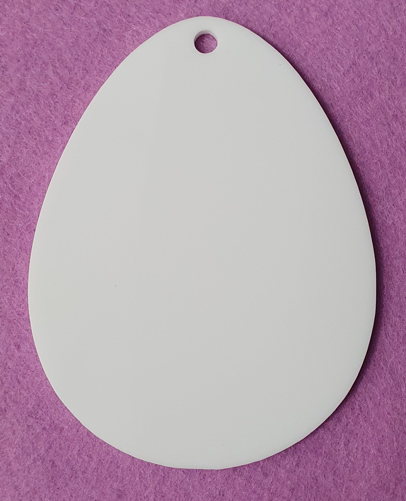 White acrylic Easter egg craft blank close up showing solid surface ideal for vinyl, UV printing and sublimation projects.