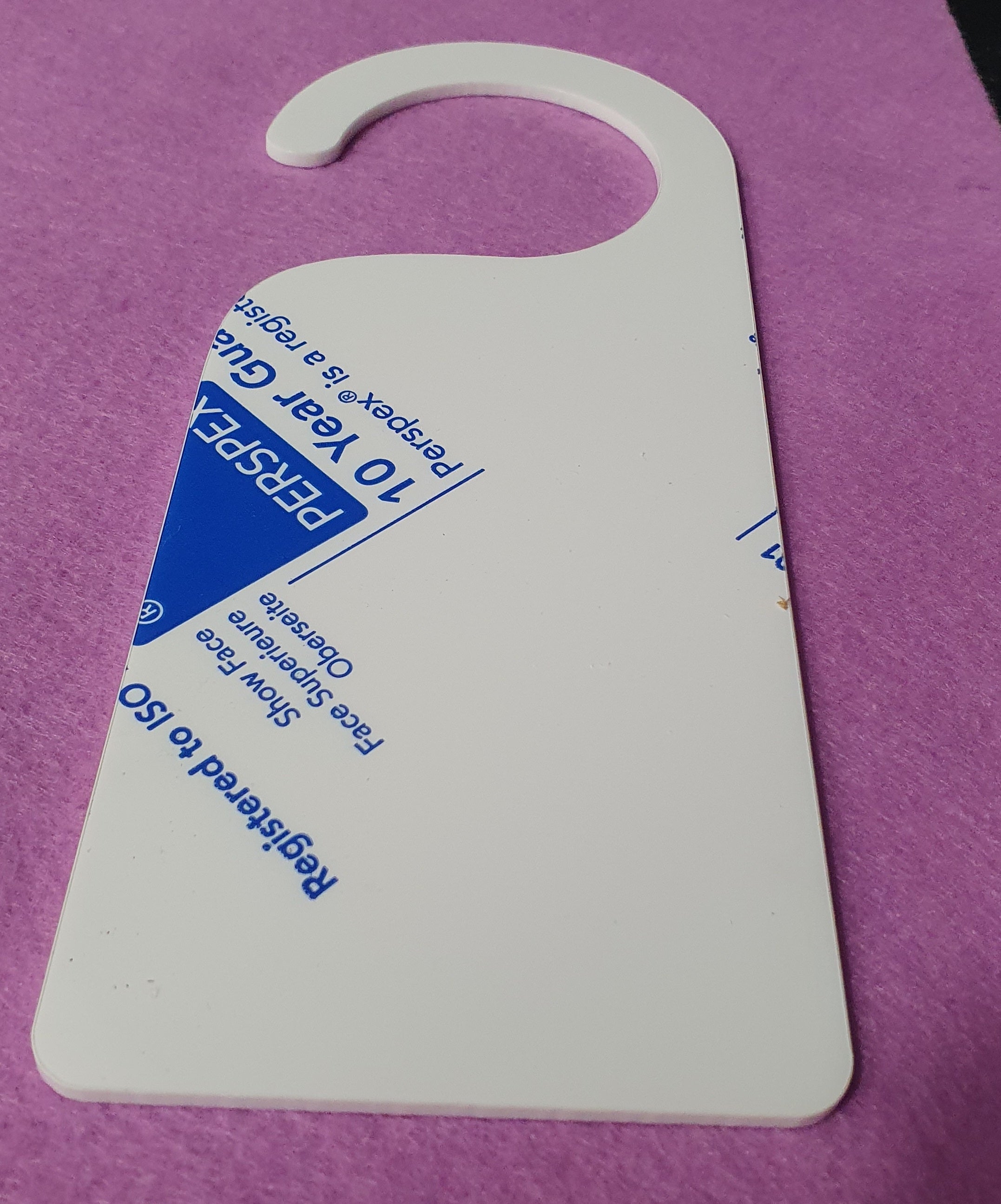 White acrylic door hanger sign blank close up showing solid surface suitable for vinyl, UV printing and sublimation projects.