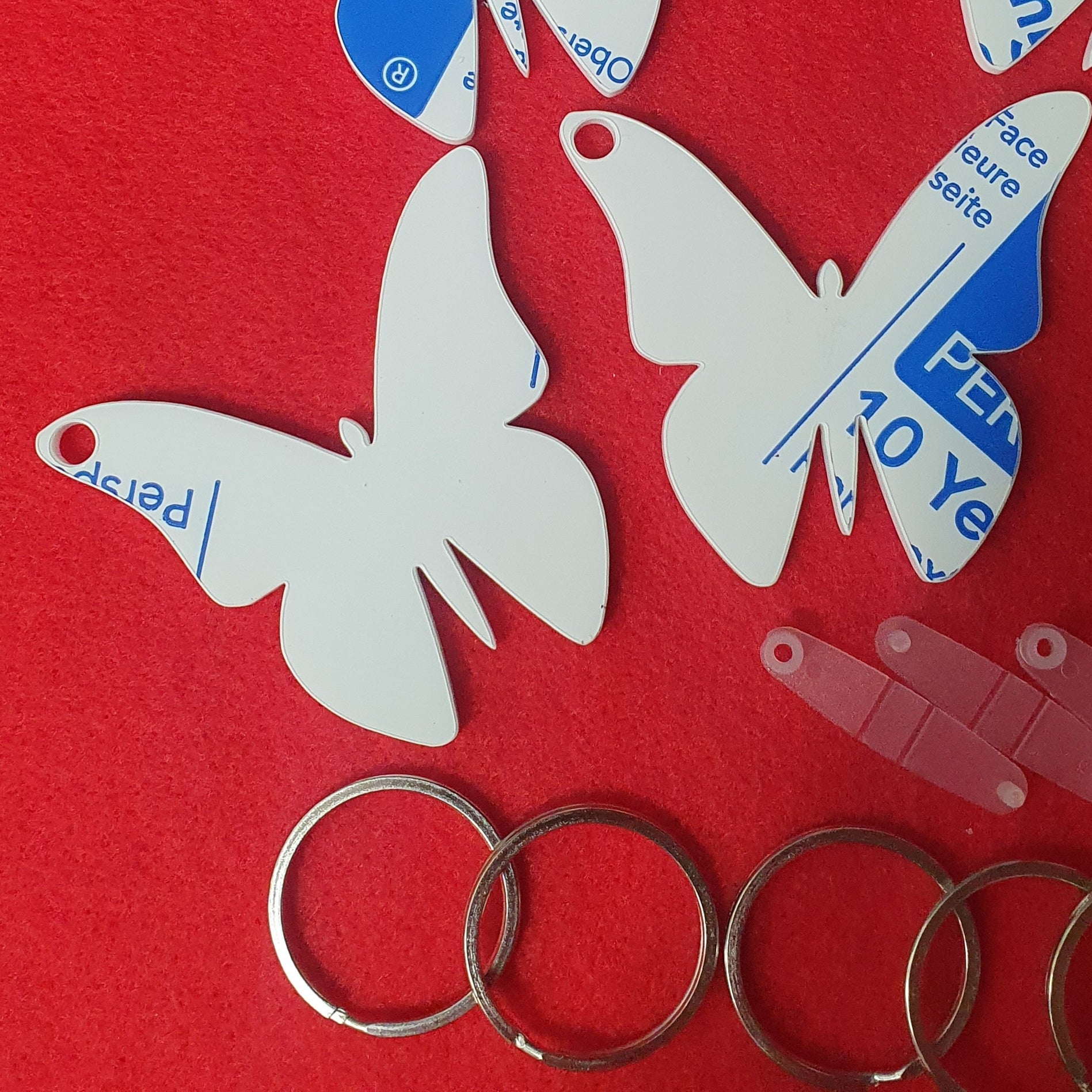 White acrylic butterfly keyring blank close up showing solid surface suitable for sublimation, vinyl and UV printing.