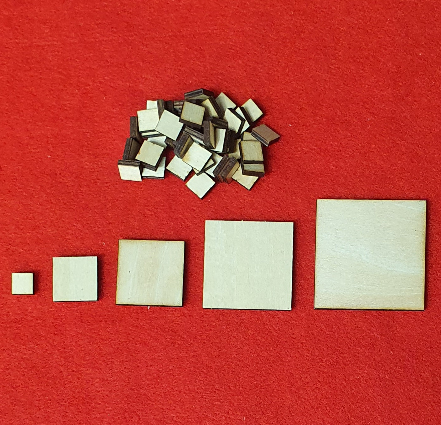 3mm basswood plywood square craft blanks in multiple sizes on red background.