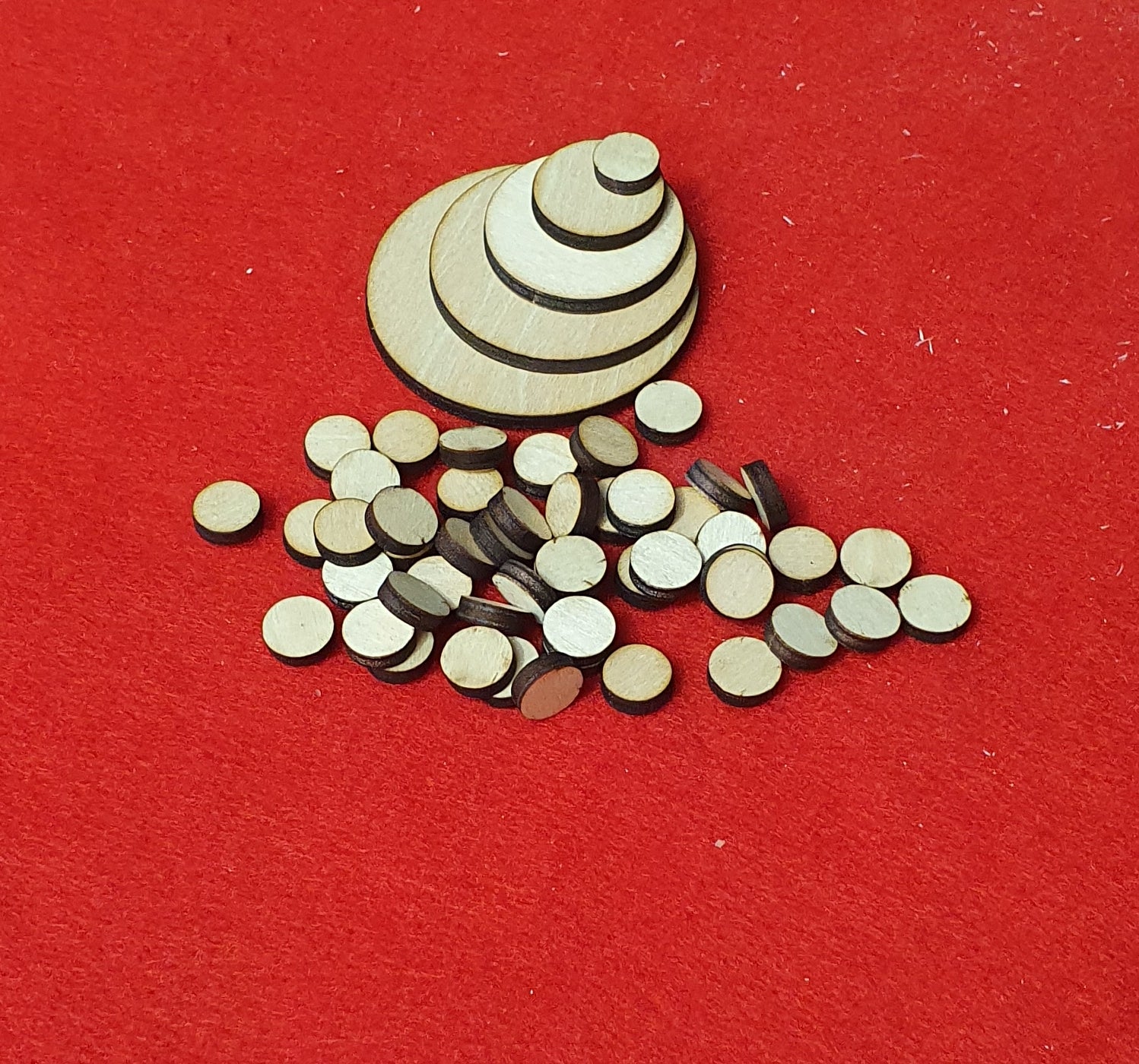 3mm basswood plywood circle craft blanks in multiple sizes on red background.