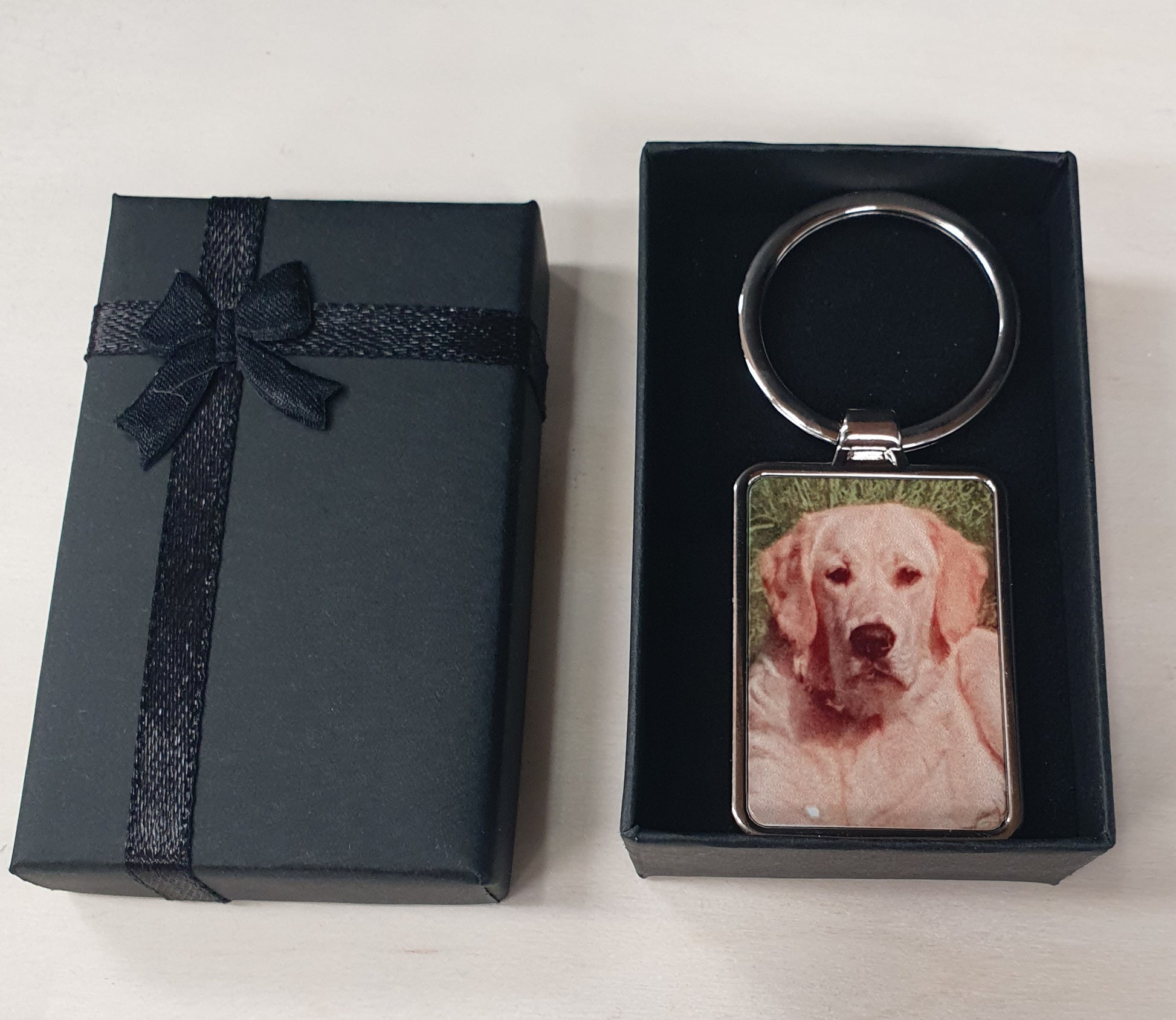 Custom photo keyring featuring a personalised image printed onto a durable rectangular metal keychain. Supplied in an elegant black presentation gift box, ideal for birthdays, anniversaries, Father's Day, Mother's Day, pet lovers or memorial keepsakes.