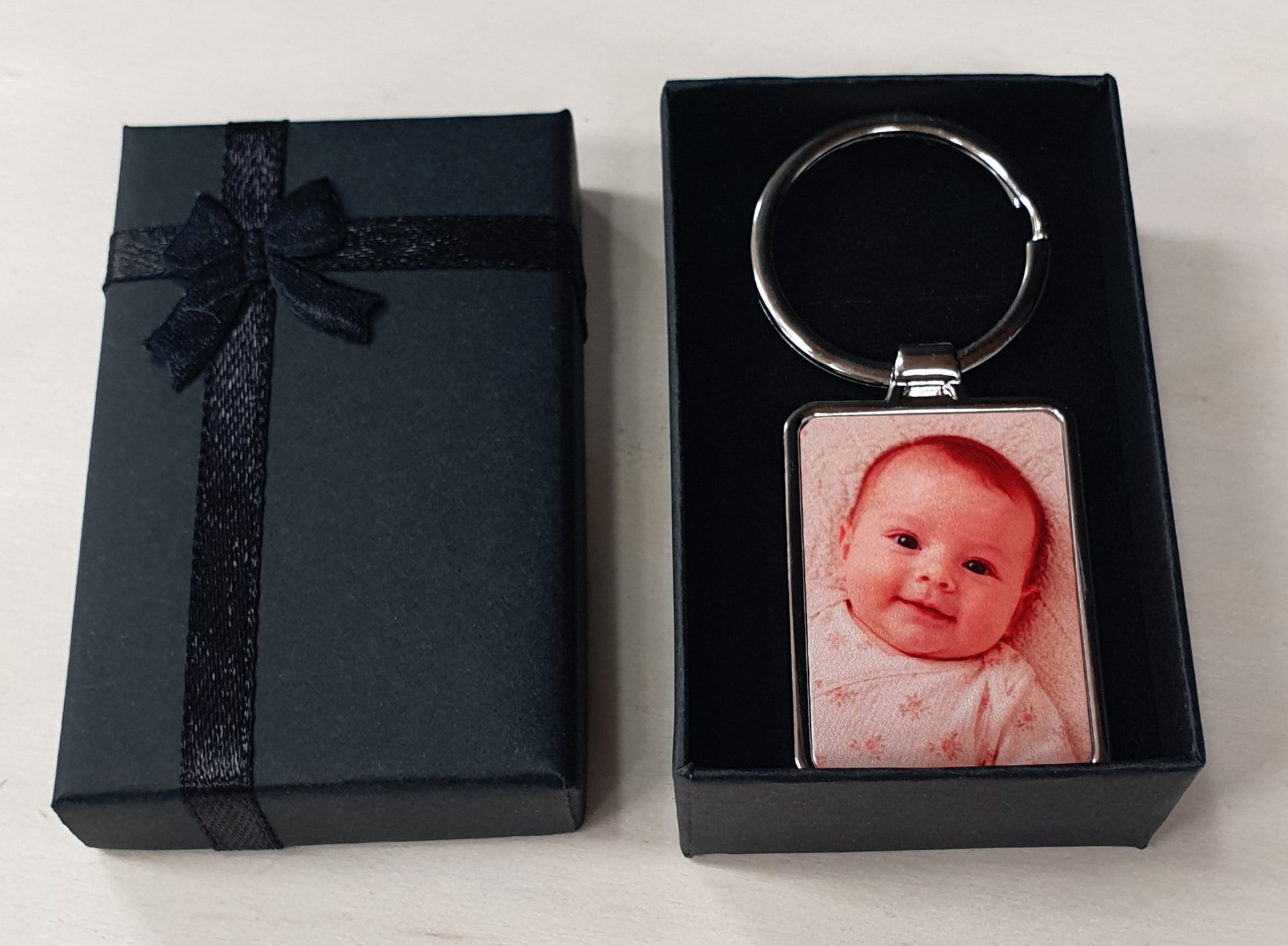 Rectangular personalised keyring with custom photo insert and optional engraved reverse side. Premium metal keychain presented in a black ribbon gift box, perfect as a personalised gift for parents, grandparents, pet owners, couples or special occasions.