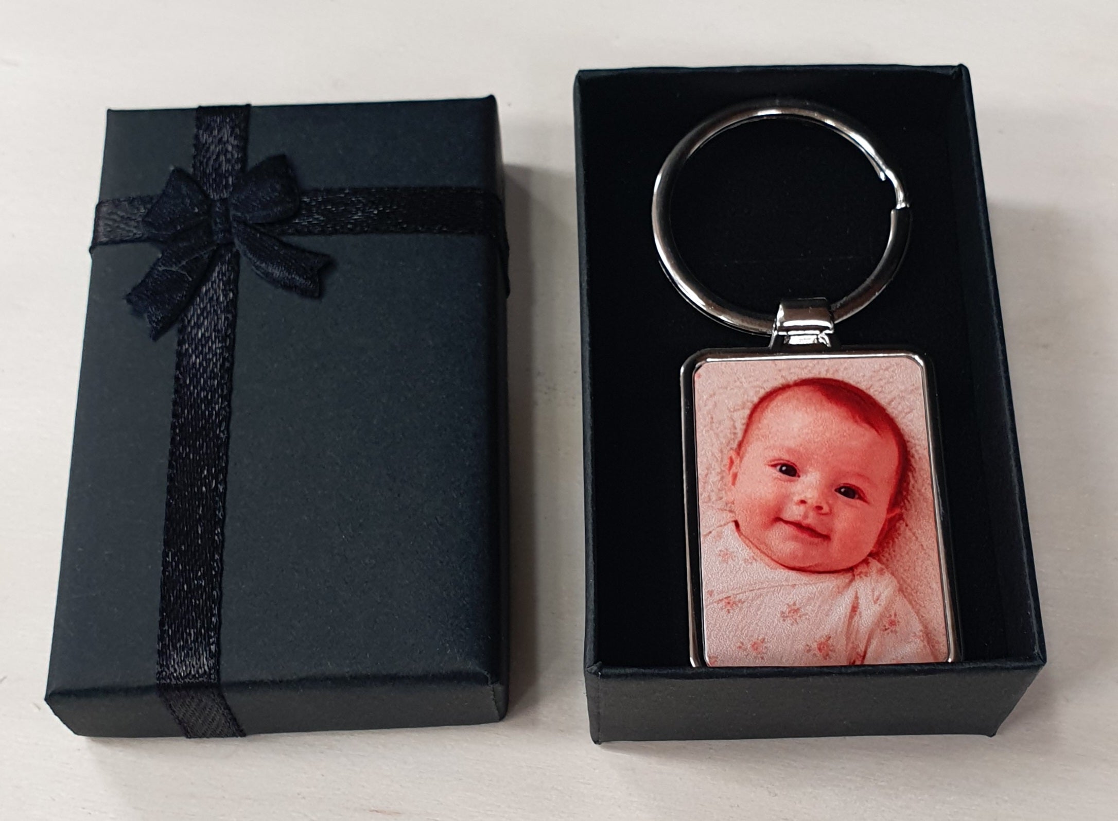 Rectangular personalised keyring with custom photo insert and optional engraved reverse side. Premium metal keychain presented in a black ribbon gift box, perfect as a personalised gift for parents, grandparents, pet owners, couples or special occasions.
