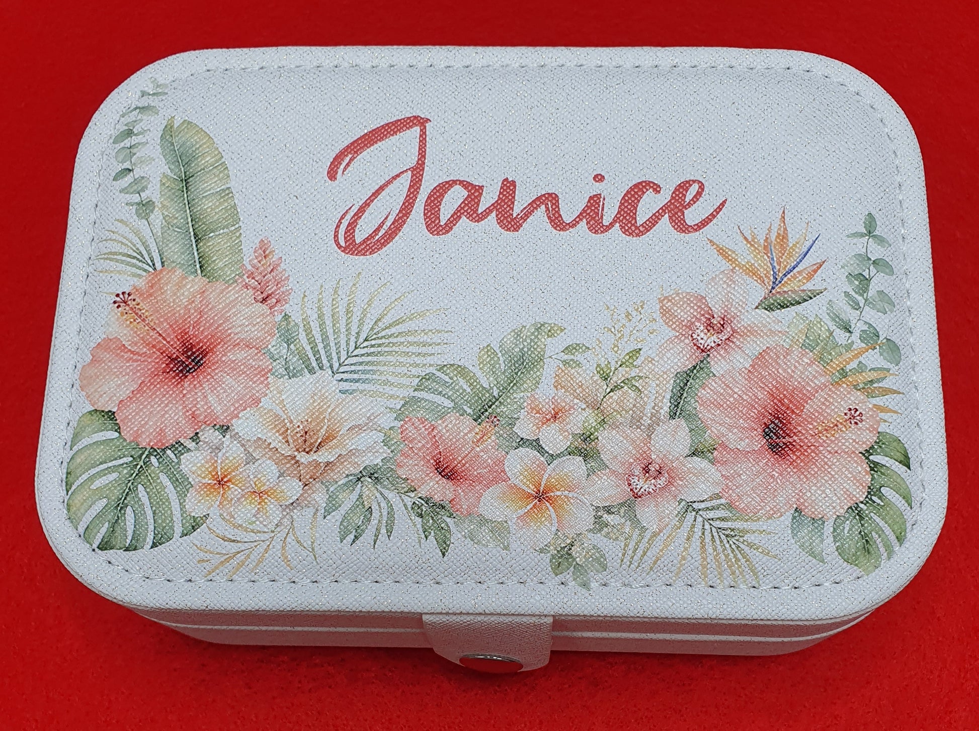 Custom floral jewellery travel case featuring a personalised name surrounded by pastel tropical flowers and greenery, perfect as a birthday, bridesmaid or Mother's Day gift.