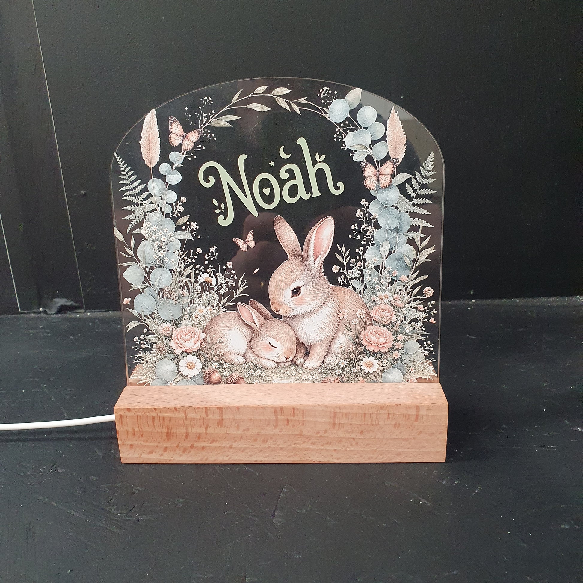 Personalised woodland nursery night light with a USB-powered wooden LED base, featuring a sweet deer and bunny design surrounded by floral and botanical artwork.