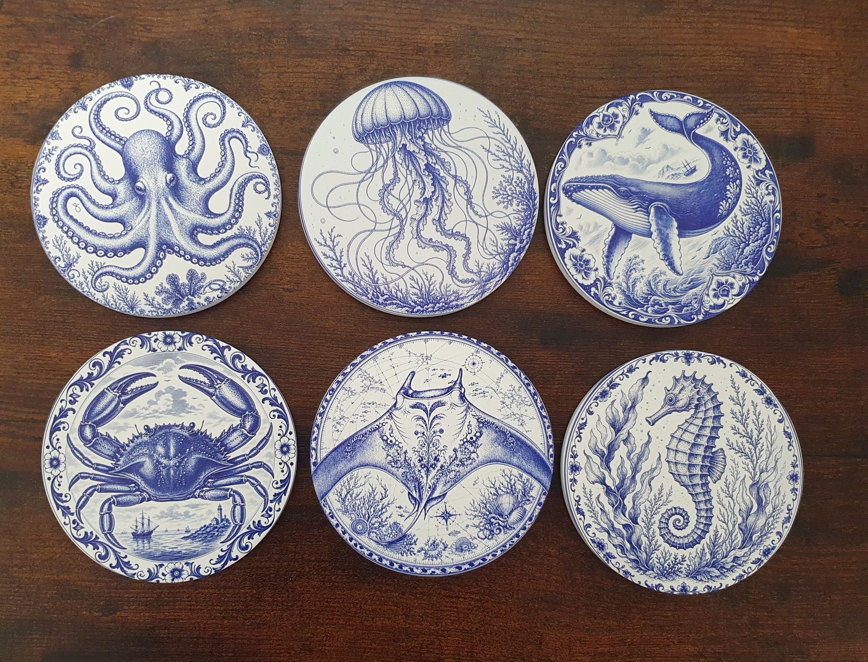 Set of six ceramic sea creature coasters featuring cobalt blue illustrations of ocean animals with cork backing.