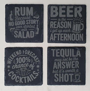 Four black slate coasters with humorous drink text designs on a white background