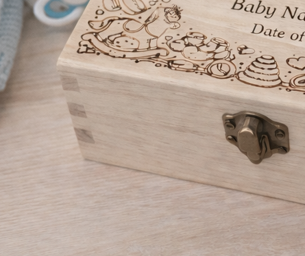 Personalised baby memory box on nursery table surrounded by baby essentials and keepsakes