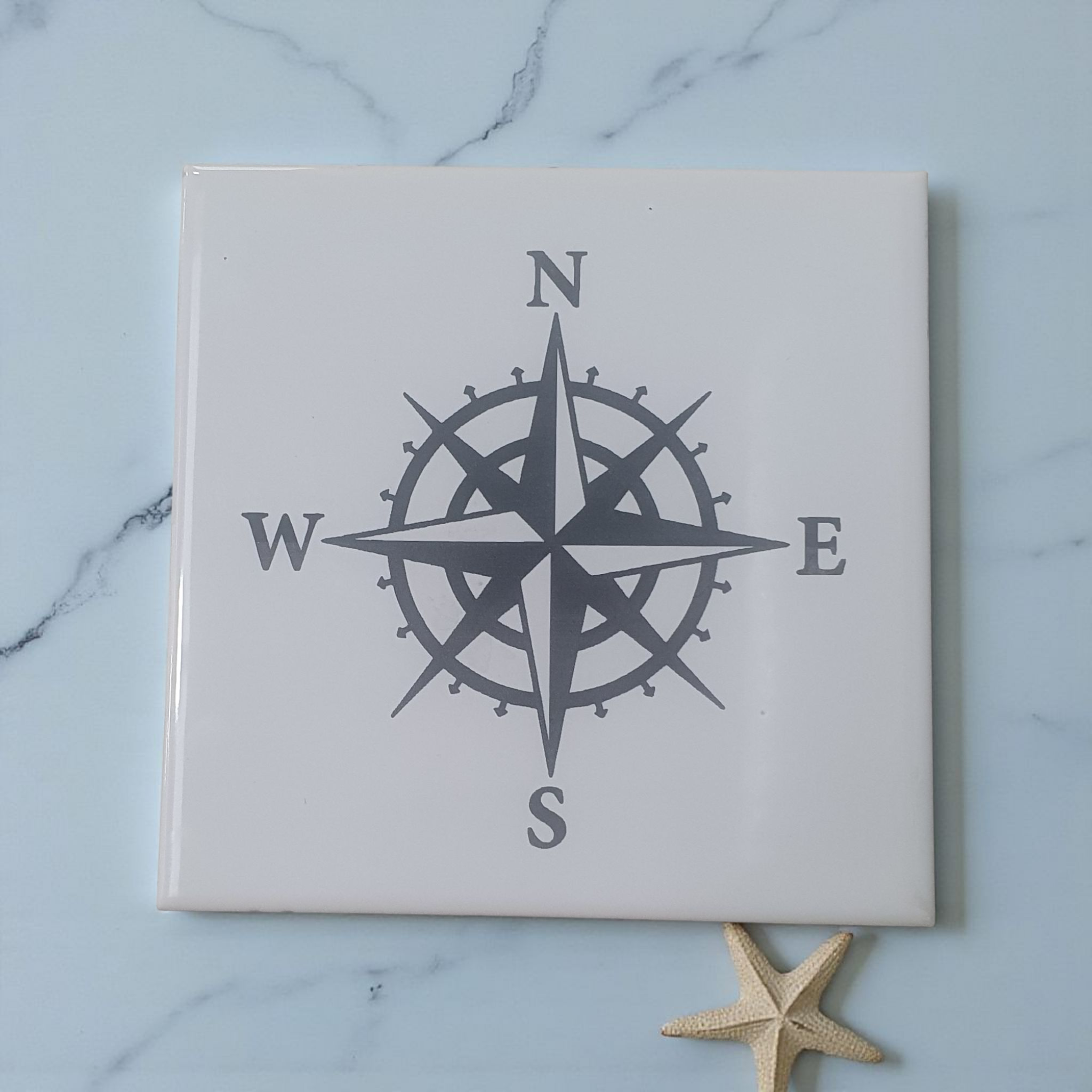 White Tile with compass engraved on it 