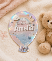 Custom pastel rainbow baby announcement plaque in a balloon shape featuring the name Amelia with birth date, time, weight and length. Decorative clouds, stars, moon and rainbow design in soft pink, blue and cream colours, perfect as a personalised newborn keepsake gift or nursery decoration.