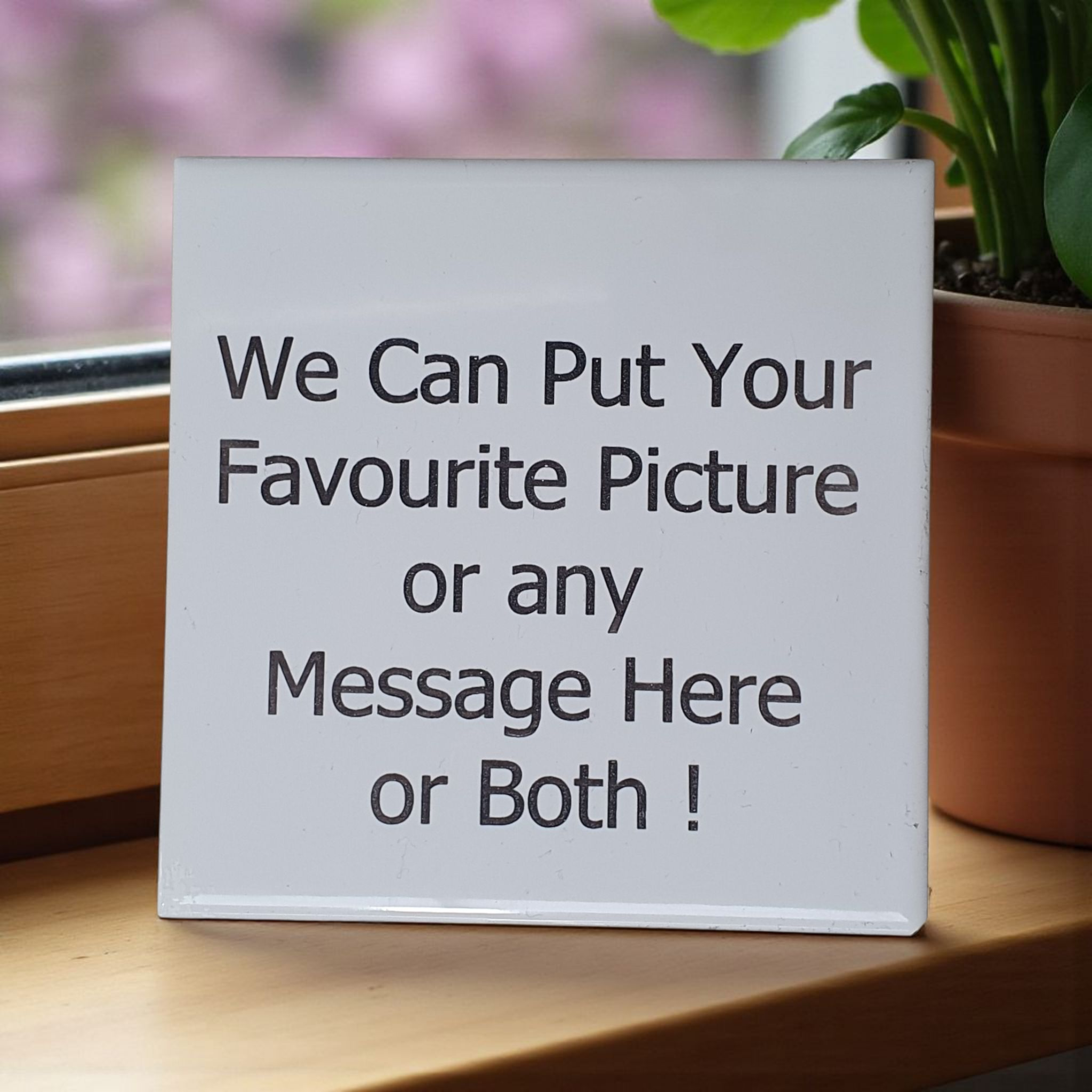 White Tile with custom text or picture  on a wooden surface with a plant in the background