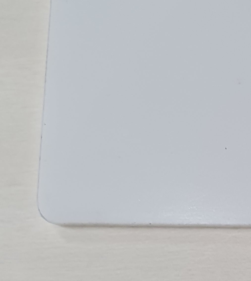 Close-up of smooth rounded corner on premium white acrylic bookmark blank with precision laser-cut finish.