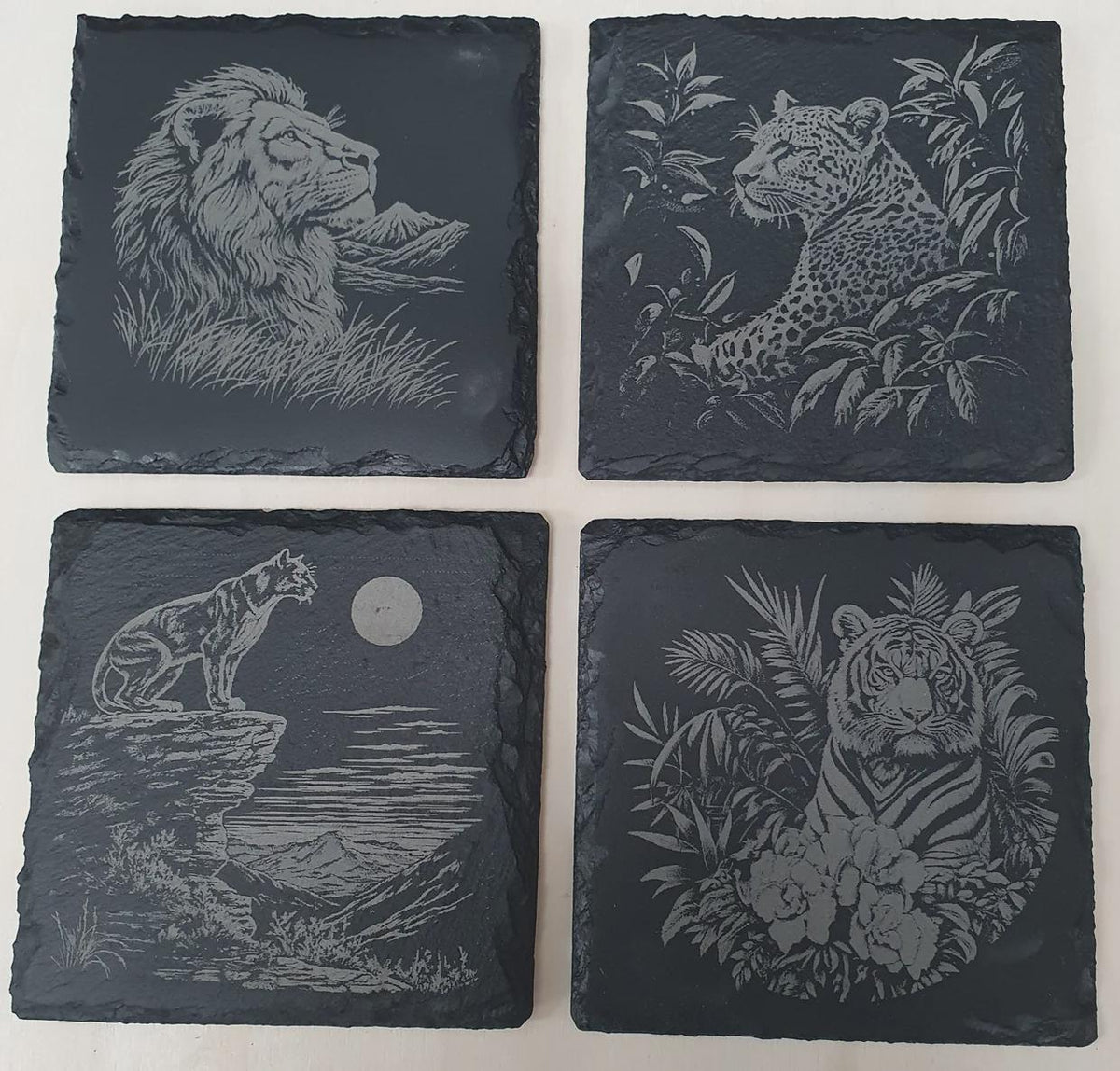 4-piece laser-engraved big cat slate tile set with detailed lion, tiger, leopard and panther designs on premium natural slate. Wildlife art tile décor set, rustic home décor, unique animal lover gift, slate coasters or wall art tiles for living room or cabin