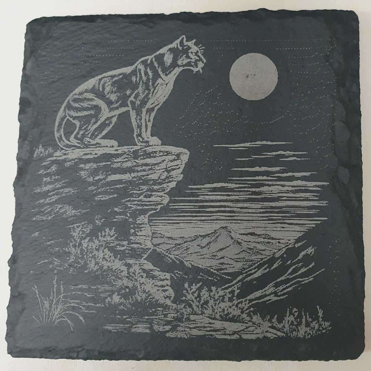 Close-up of laser-engraved slate tiles featuring intricate big cat artwork — lion, tiger, leopard and panther — on natural slate with rich texture and fine detail. Handcrafted wildlife décor, laser etched tile art and collectible set