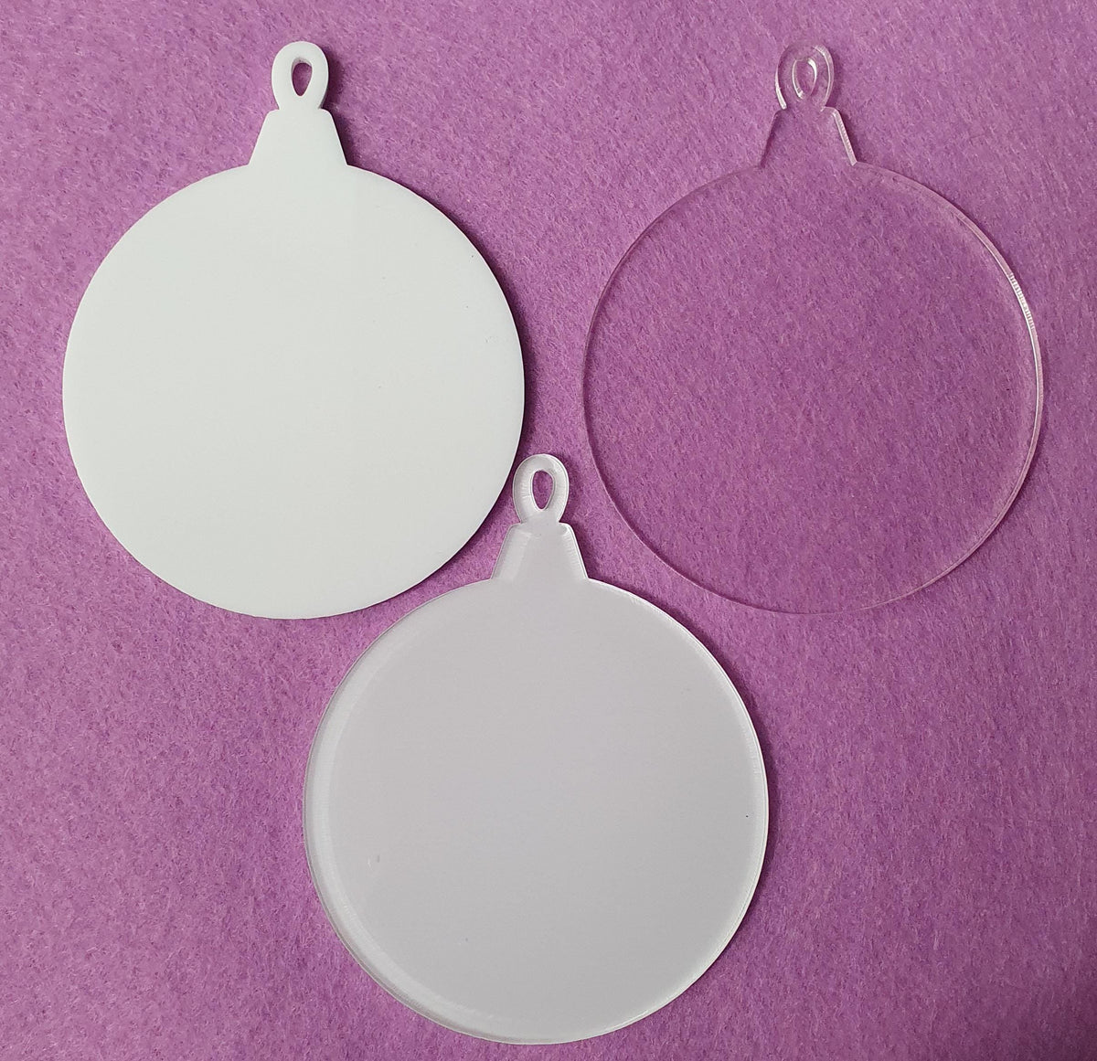 Set of 3mm acrylic bauble blanks in clear, white and clear with white sublimation reverse finishes, sized 7.5cm wide by 9.5cm tall with hanging loop at the top.