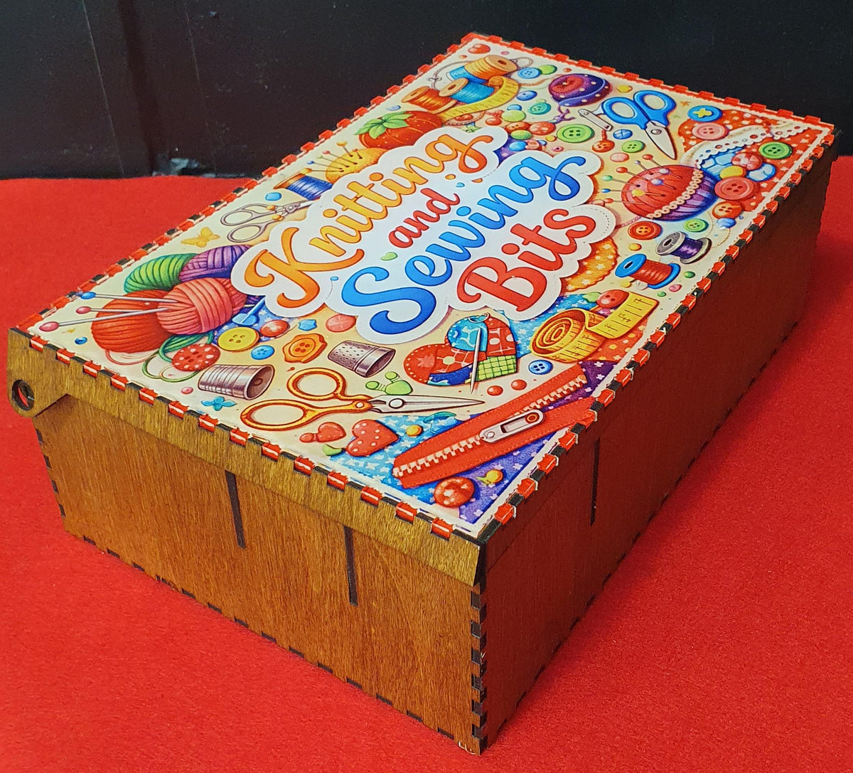 Open wooden craft organiser box showing multiple compartments for sewing and knitting supplies