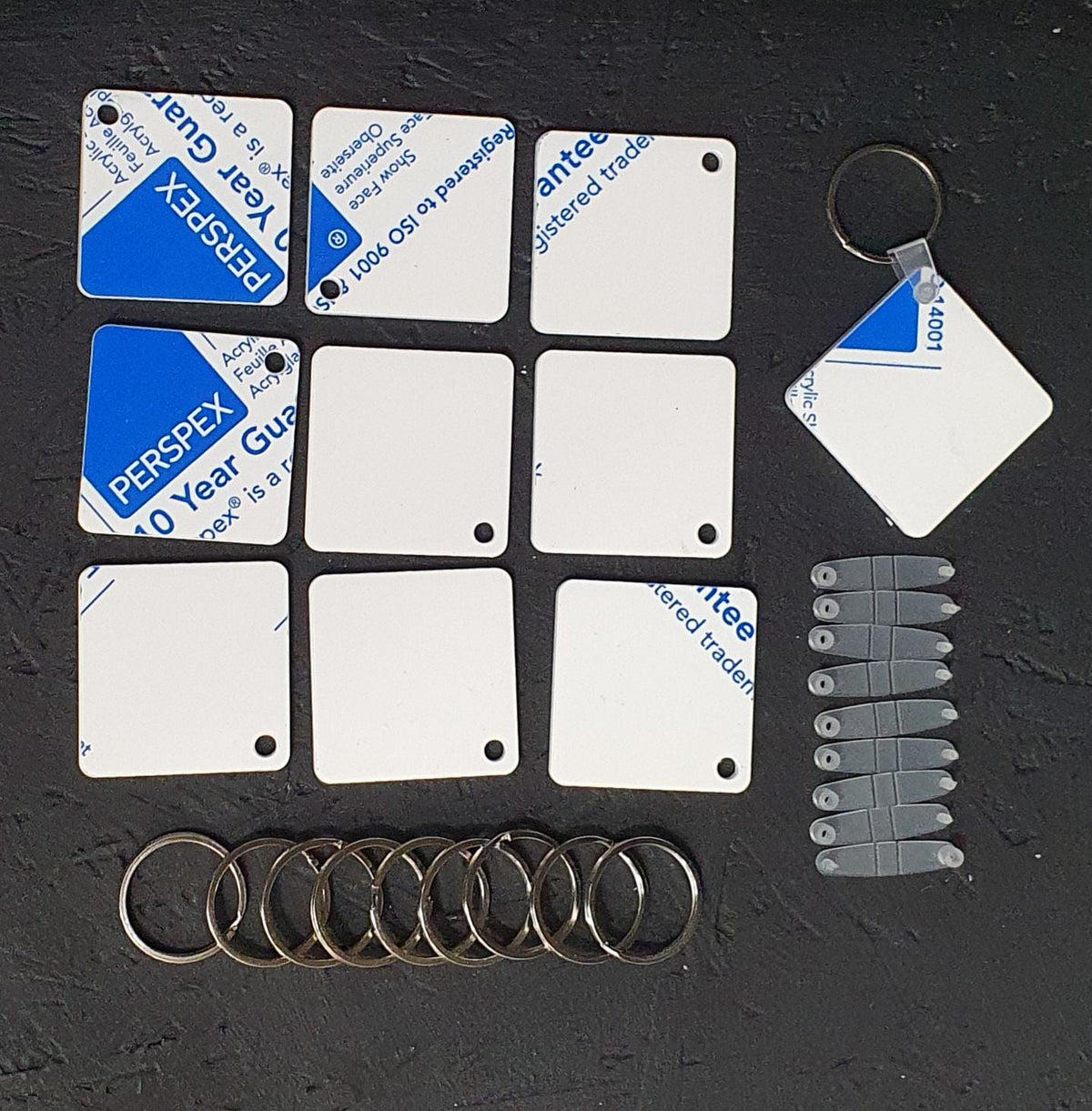 Square white cast acrylic keyring blank approximately 50x50mm with clear connector tab and 30mm keyring, suitable for business branding.
