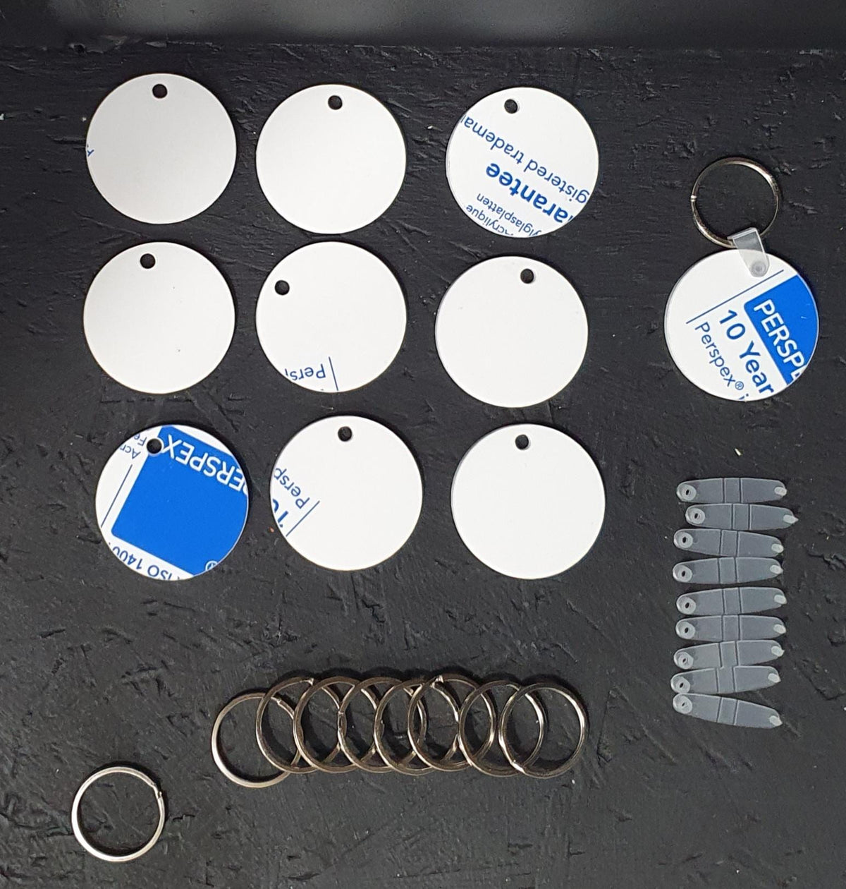 Round white acrylic circle keyring blank with protective film and metal split ring, perfect for custom printing and craft use.