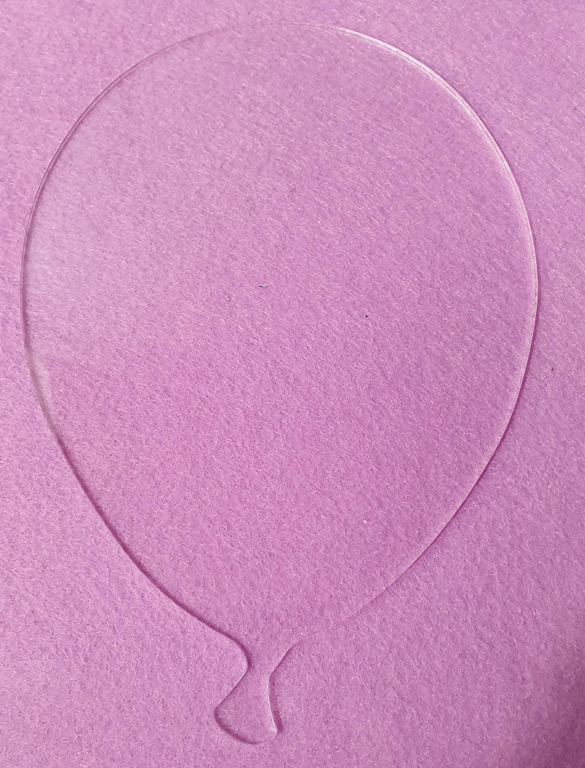 Clear acrylic balloon shape blank displayed on pink background highlighting transparent finish and clean outline for personalised decorations.