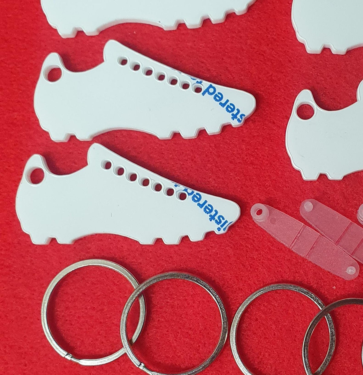 Football boot acrylic keyring blanks supplied with clear snap clips and metal split rings ready for personalised team gifts.