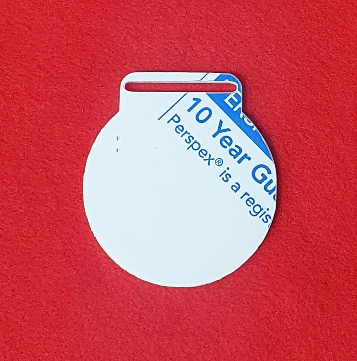 8cm round acrylic medal blank with ribbon slot, shown in white cast acrylic with protective film.