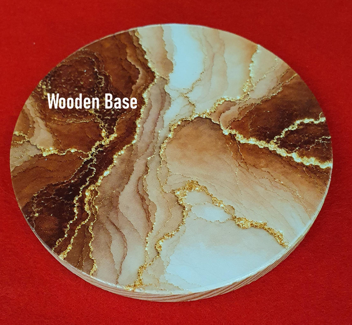 Terracotta marble effect coaster with textured gold veining held in hand, round 10cm cork backed drink coaster warm home decor