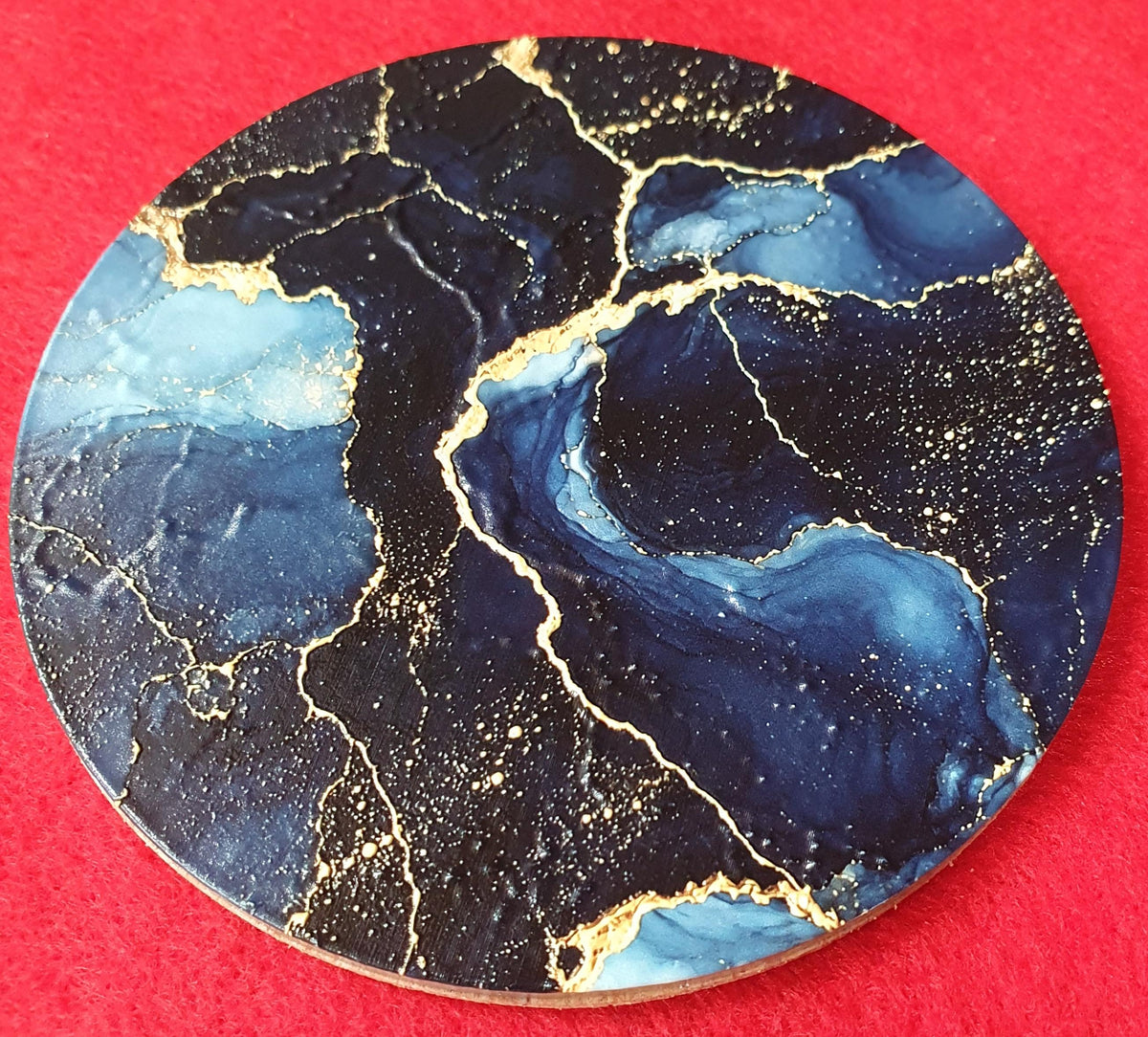 Close-up of navy blue and gold drinks coaster available in acrylic, wood or ceramic finish.