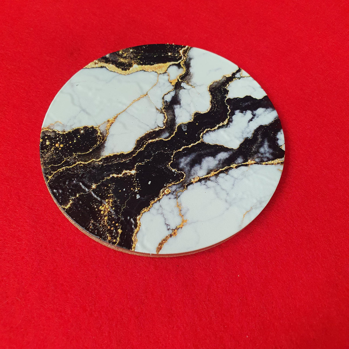 Luxury black marble effect coaster with white marble sections and elegant gold veining.