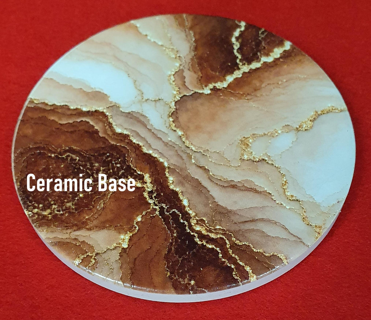 Terracotta marble effect coaster with textured gold veining held in hand, round 10cm cork backed drink coaster warm home decor