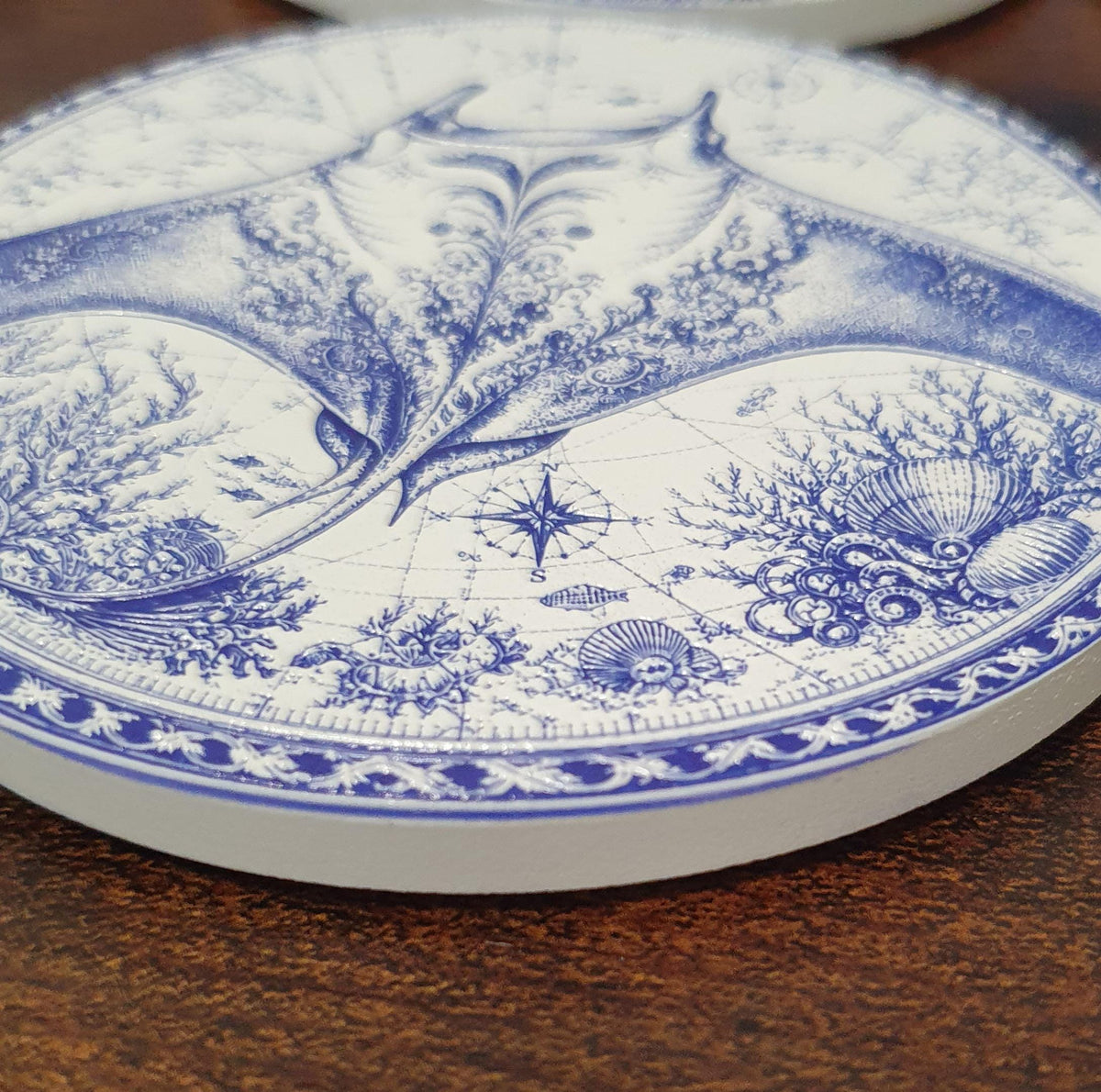 Set of six ceramic sea creature coasters featuring cobalt blue illustrations of ocean animals with cork backing.