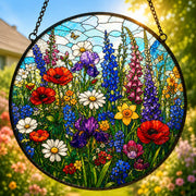 Round stained glass style floral suncatcher featuring colourful English wildflowers, bright red poppies, daisies, purple irises, blue delphiniums and pink foxgloves against a sunny countryside background.