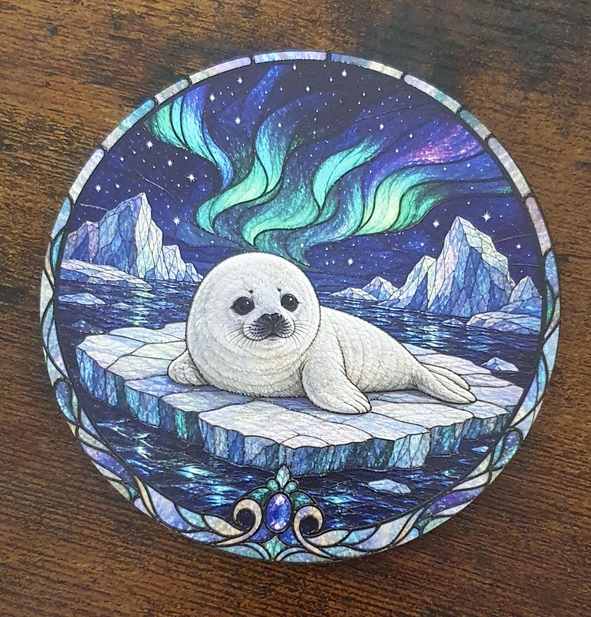 Stained-glass effect baby seal coaster resting on Arctic ice beneath colourful Northern Lights with icy mountains and star-filled night sky.