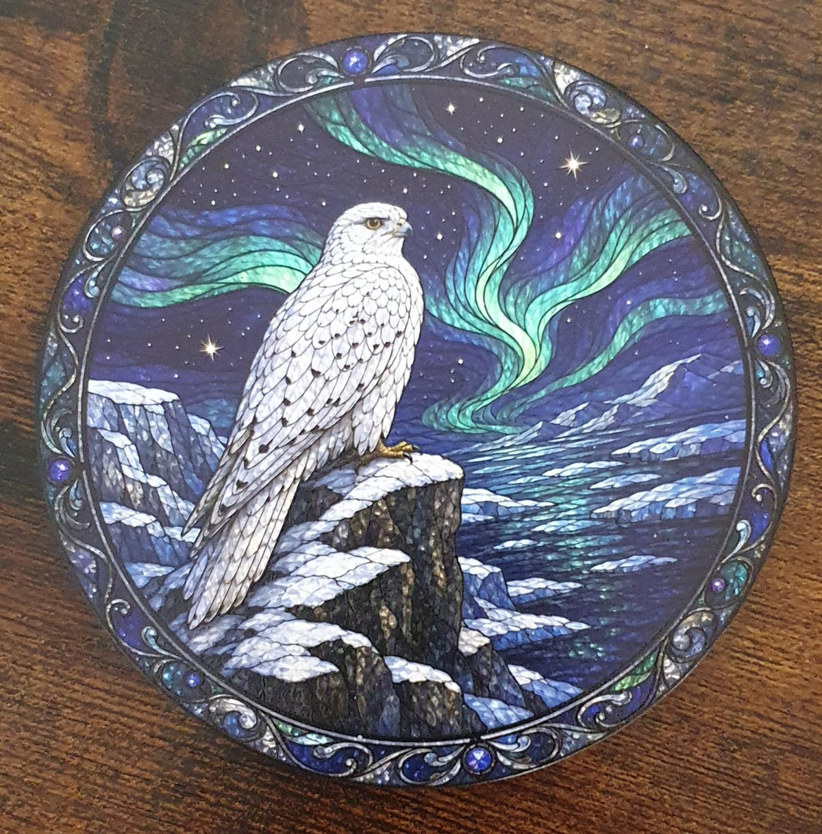 Snowy falcon stained-glass artwork coaster perched on icy cliffs beneath glowing Northern Lights with Arctic landscape and frozen sea.