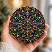 Colourful stained-glass effect mandala coaster featuring intricate peacock feathers, jewel-toned floral patterns and elegant gold detailing on a circular design.