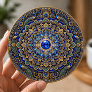 Luxury stained-glass effect peacock mandala coaster featuring intricate blue and gold floral patterns, elegant peacocks and a sapphire gemstone centre.