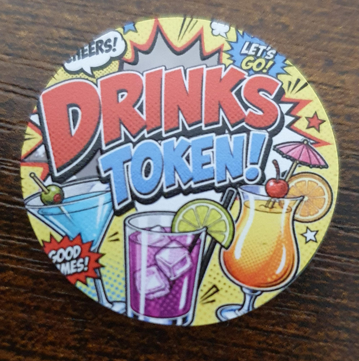 40mm Comic Pop Art Drinks Token featuring colourful comic book graphics and cocktail illustrations for redeeming drinks at the bar.