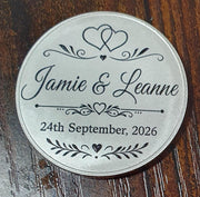 Personalised silver wedding keepsake coin engraved with couple's names and wedding date.