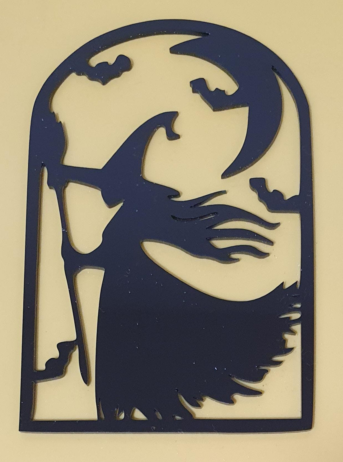 Black laser-cut acrylic Halloween decoration featuring a witch stirring a bubbling cauldron beneath a crescent moon and flying bats.
